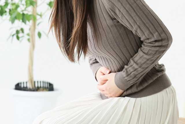 お腹を痛めた女性の写真